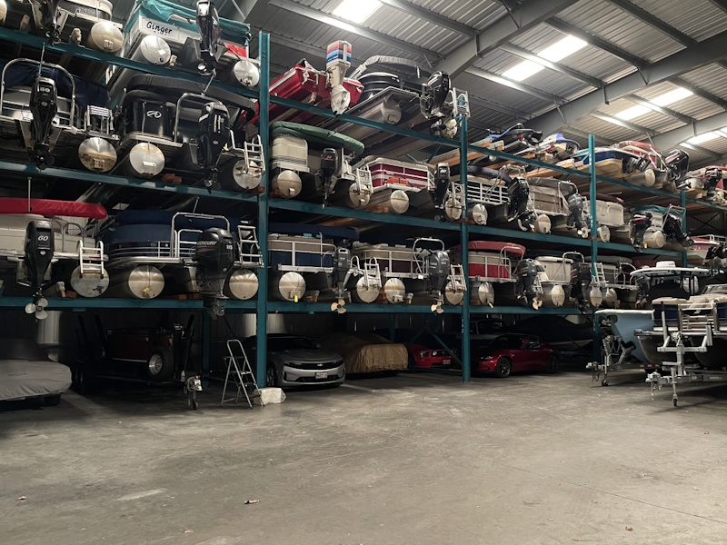 Pontoons stored on teal steel racks inside the building